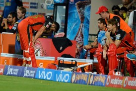 Royal Challengers Bangalore captain and batsman Virat Kohli bends down with disappointment in the players dug out after being bowled out during the final Twenty20 cricket match of the 2016 Indian Premier League (IPL) between Royal Challengers Bangalore and Sunrisers Hyderabad at The M. Chinnaswamy Stadium in Bangalore on May 29, 2016.